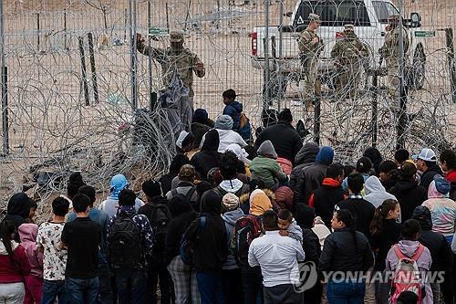 불법 이민자 100여 명이 21일(현지시간) 텍사스 남부 엘패소 국경 철조망을 뚫고 월경을 시도하고 있다.