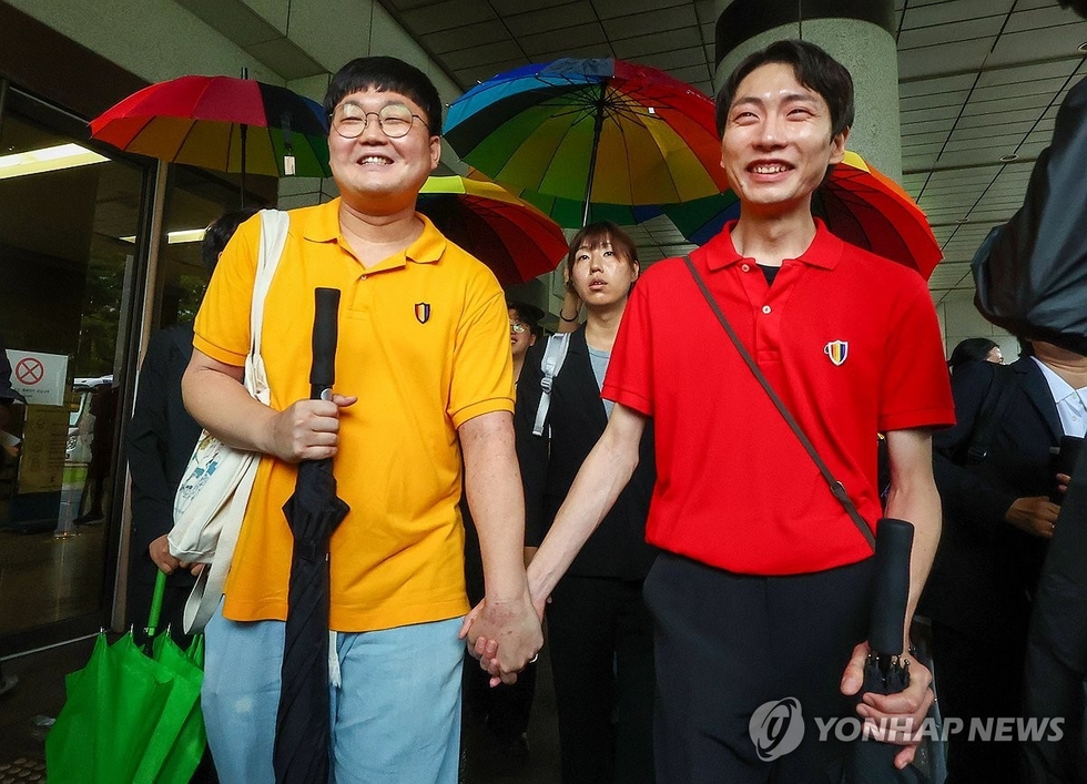 동성 연인 건강보험 피부양자 자격과 관련해 국민건강보험공단을 상대로 제기한 보험료 부과 처분 취소 소송에서 승소한 소성욱씨와 김용민씨(오른쪽)가 손을 잡고 밝은 표정으로 서울 서초구 대법원을 떠나고 있다. /연합