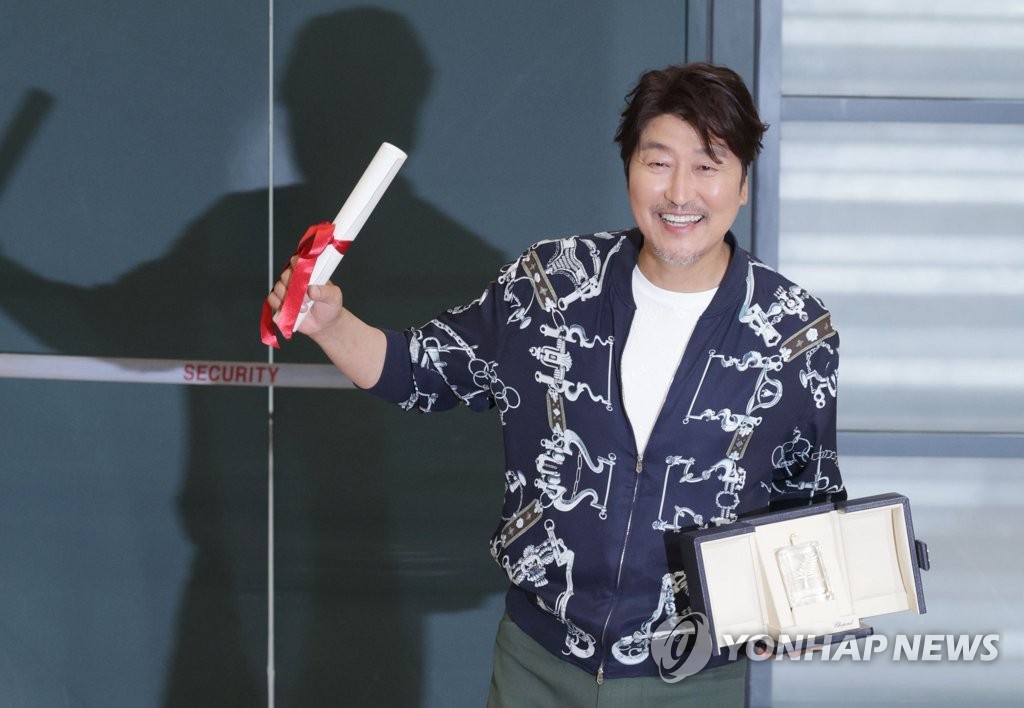 칸국제영화제에서 남우주연상을 수상한 배우 송강호가 30일 오후 인천국제공항을 통해 귀국, 트로피를 들고 포즈를 취하고 있다. 2022.5.30